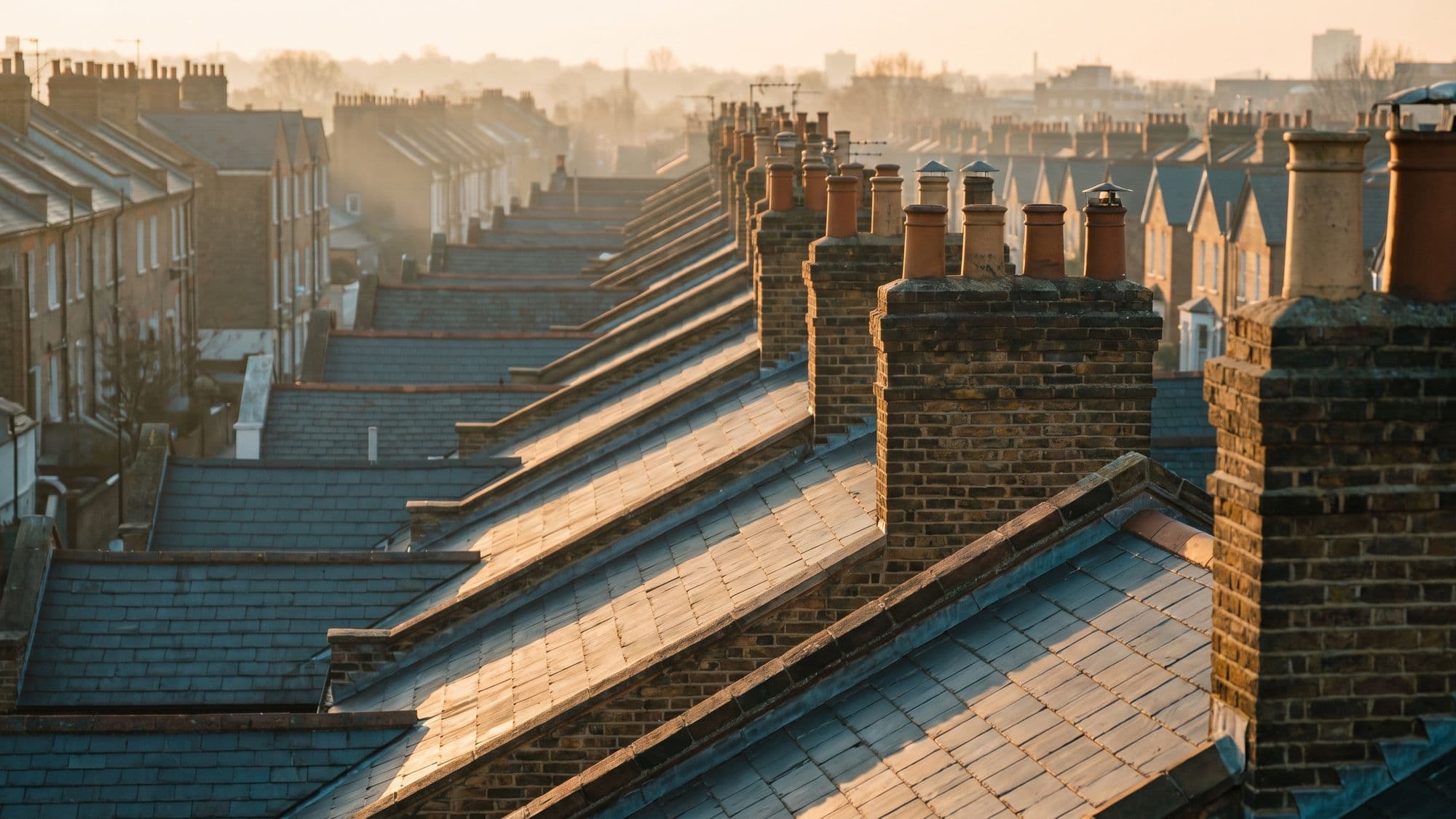 British terraced rooftops and chimney stacks stretching into the distance at golden hour