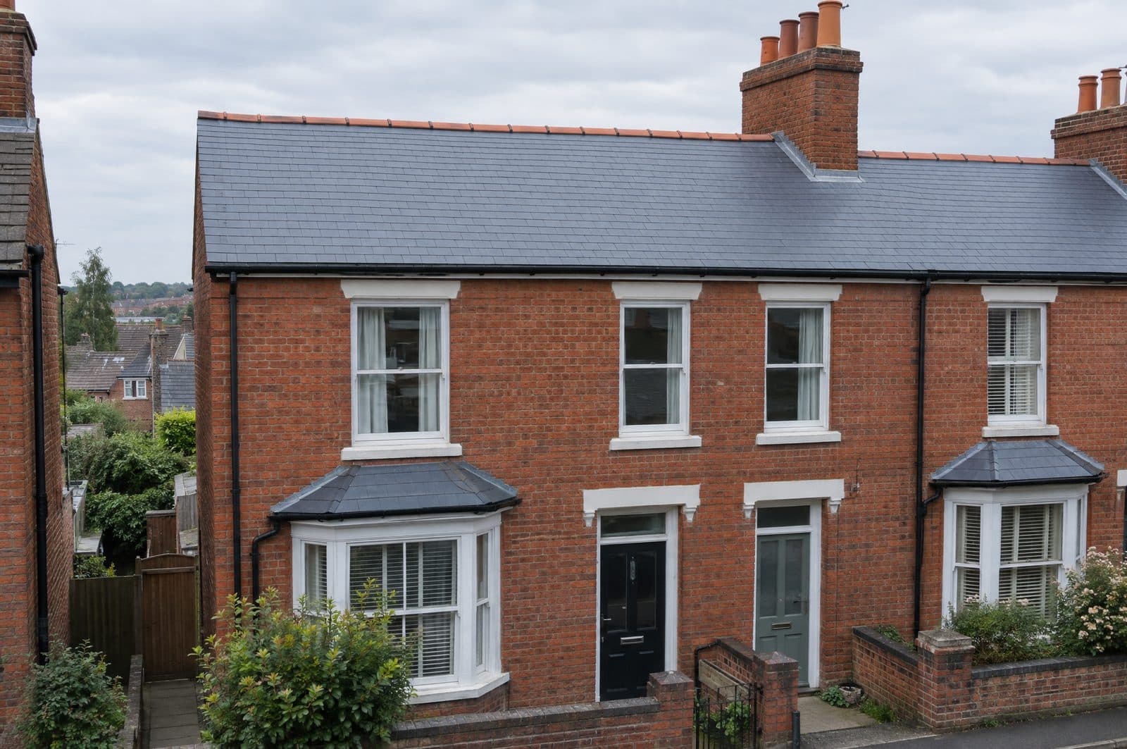 The same terraced house with a new natural slate roof, clay ridge tiles and new lead at the chimney